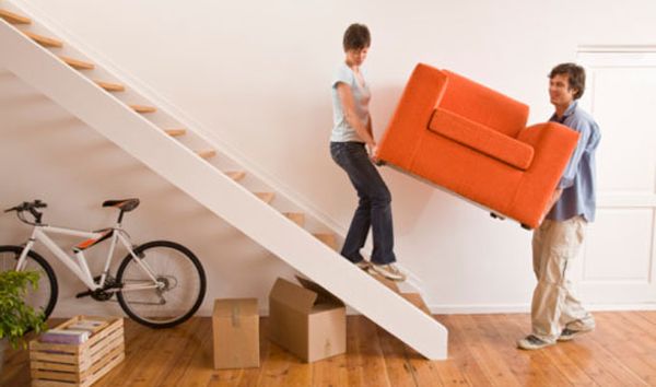 Couple lifting couch up the stairs